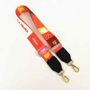 Macro view of adjustable wide shoulder strap with colorful graffiti print and gold hardware