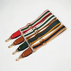 Detail of four colorful woven replacement bag straps with gold hardware and leather ends