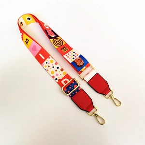 Close-up of colorful pop art fabric bag strap with adjustable buckle and gold metal hook