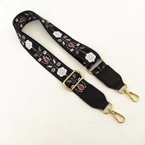 Close-up of wide floral embroidery shoulder strap with gold metal lobster clasps