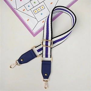Detail view of purple striped woven wide bag strap with gold metal hooks and hardware