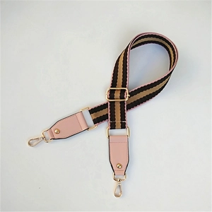 Detail of adjustable woven bag strap with pink and brown stripes and gold hardware