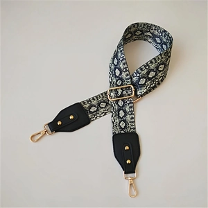 Adjustable snake print bag strap with gold hardware and black leather ends