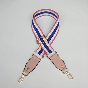 Close-up of pink and purple woven adjustable strap with golden metal hardware and swivel hooks
