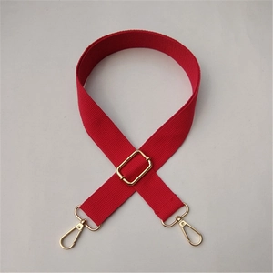 Close-up of adjustable red fabric shoulder strap with premium gold metal hardware