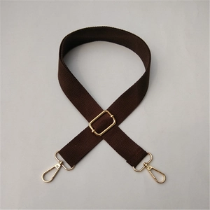 Detail of dark brown canvas strap with adjustable golden metal buckle and swivel hooks