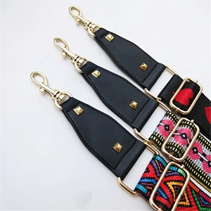 Detail of adjustable wide bag straps with colorful patterns and gold-plated metal hardware