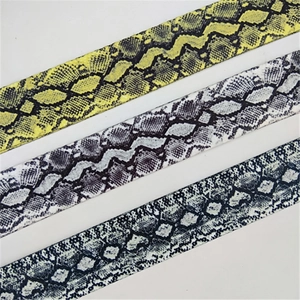 Detailed macro view of adjustable snakeskin pattern purse straps in multiple colors