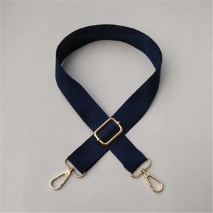 Detail of navy blue cotton woven shoulder strap with adjustable gold-tone metal buckles