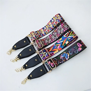 Detail of adjustable patterned wide shoulder straps with gold metal clasps and leather ends