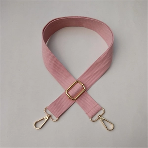 Detail of pink adjustable canvas shoulder strap with polished gold metal swivel hooks