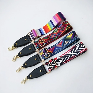 Detail of adjustable woven purse straps with ethnic patterns and gold metal hooks
