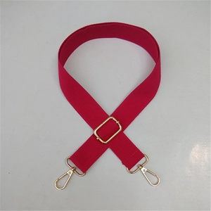 Detail of rose red adjustable canvas bag strap with golden metal lobster clasps