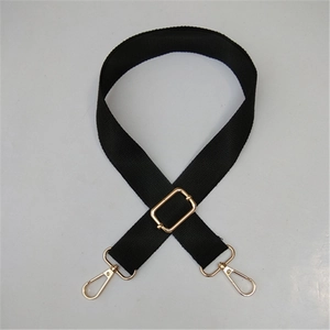 Detail of adjustable black cotton shoulder strap with gold-plated metal lobster buckles