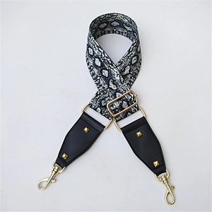 Detailed view of adjustable snake skin pattern wide bag strap with gold studs and hardware
