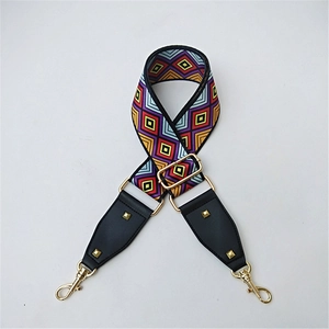 Detail of colorful geometric woven strap with black leather ends and gold metal buckles