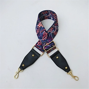 Close-up of ethnic floral pattern webbing strap with leather ends and golden rivets