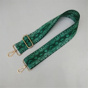 Close-up of green snakeskin wide shoulder strap with adjustable golden metal buckle