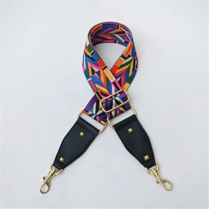 Close-up of ethnic geometric pattern strap with gold buckles and black leather ends