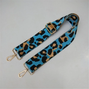 Close-up of blue leopard print wide adjustable shoulder strap with gold metal hooks