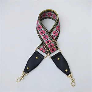 Close-up of geometric pattern woven bag strap with golden buckles and leather details