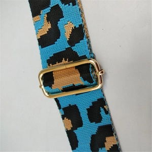 Close-up of adjustable leopard print canvas bag strap with gold metal buckle hardware