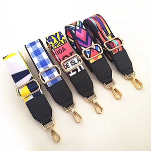 Detailed view of colorful ethnic style wide bag straps with metal hardware and leather ends