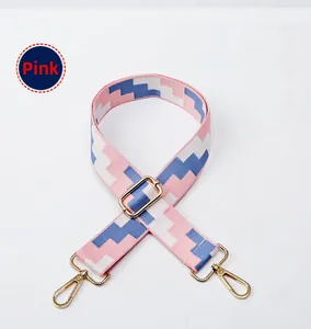 Adjustable woven purse strap with pink geometric texture and gold metal clasps