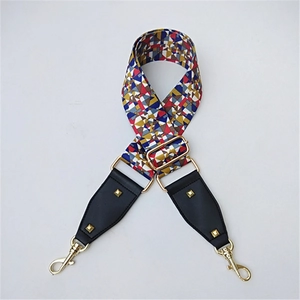 Close-up of colorful geometric woven wide shoulder strap with gold buckle and leather ends