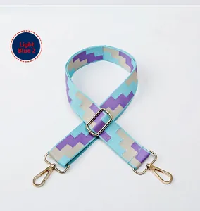 Close-up of adjustable wide woven shoulder strap in light blue geometric pattern with gold hooks
