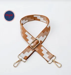 Macro view of adjustable wide fabric strap with khaki geometric pattern and gold hardware