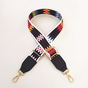 Close-up of ethnic geometric pattern bag strap with gold metal hardware and black leather
