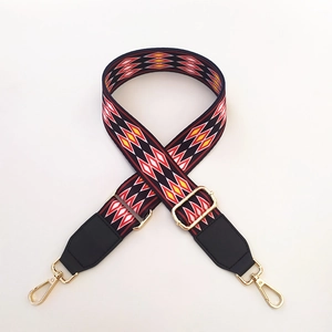 Close-up of ethnic geometric pattern webbing strap with gold metal lobster clasps