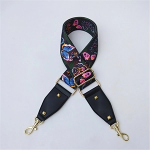 Detail of colorful butterfly print fabric strap with gold metal hooks and leather ends