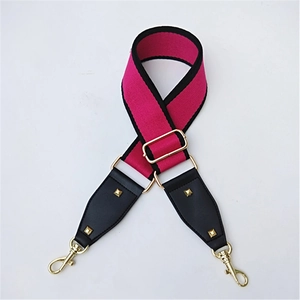 Detail of rose red wide bag strap with gold rivets and metallic swivel lobster clasps