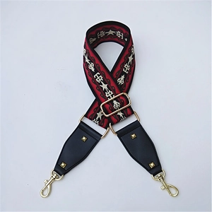 Close-up of wide ethnic woven strap with red-black patterns and gold lobster clasps