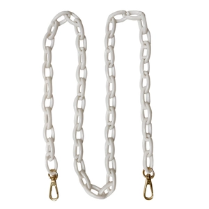 Close-up of chunky cream acrylic chain strap with gold metal lobster clasps for bags