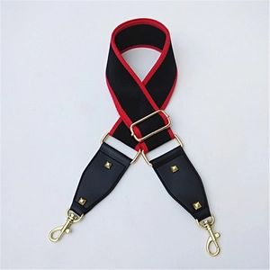 Detail of adjustable black woven strap with red edges and gold metal snap hooks