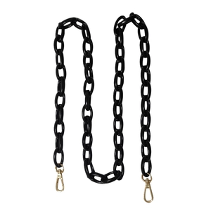 Detail of chunky black acrylic bag chain with durable gold lobster clasps and thick links