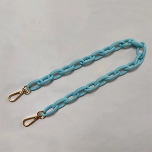 Close-up of light blue acrylic chain strap with gold metal lobster clasps for handbags