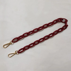 Macro shot of dark red acrylic chunky chain strap with gold metal lobster clasps