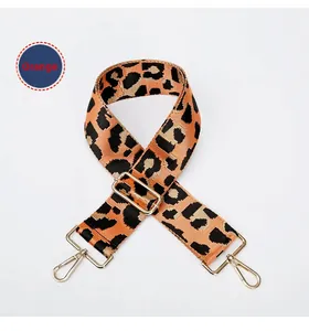 Detail van de verstelbare oranje luipaardprint riem met gouden metalen haken