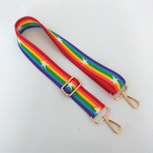 Rainbow striped canvas bag strap with white stars and gold metal clasps on white background