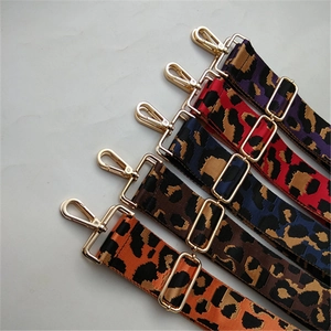 Macro view of adjustable leopard print shoulder straps with glossy gold metal hardware