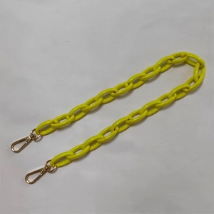Close-up of bright yellow acrylic chain strap with gold-tone lobster clasps for bags