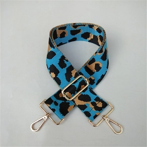 Close-up of leopard print bag strap in bright blue with golden lobster clasps and metal buckles