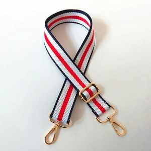 Macro shot of red, white, and blue striped fabric strap with golden metal swivel hooks