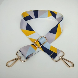 Close-up of geometric pattern shoulder strap with golden metal lobster hooks and buckle