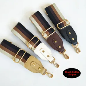 Close-up of wide striped crossbody bag straps with colorful leather ends and gold metal clips