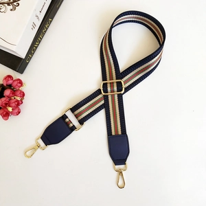 Detail of navy nylon strap with classic stripes and gold metal lobster clasps